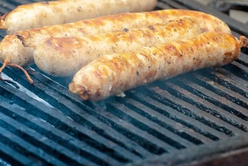 process of cooking sausages in a barbecue. juicy and fragrant meat languishes under the smoke of a fire. rest and cooking in nature