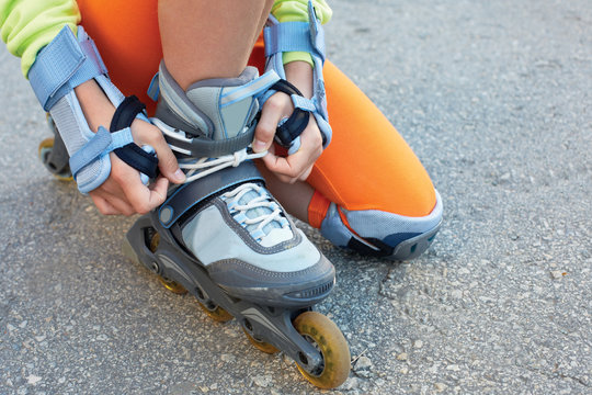 Setting of laces on black roller skates. Active sports.