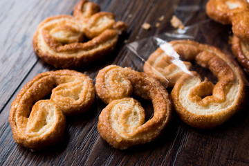 Palmier Cookies in Black Plate on Wooden Surface.