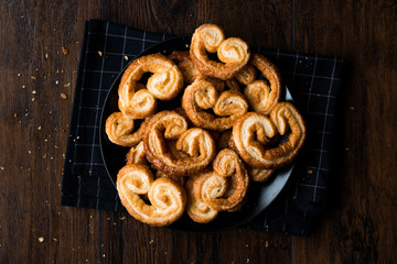 Palmier Cookies in Black Plate on Wooden Surface.