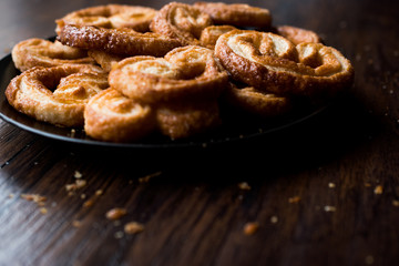 Palmier Cookies in Black Plate on Wooden Surface.