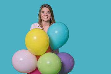 Fototapeta na wymiar Beautiful young woman with balloons on isolated blue background
