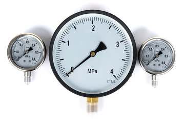 The pressure sensor in the pipeline is a manometer. Three gauges of different sizes on a white...