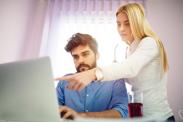 Two young coworkers working together.