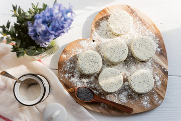 raw cheese cakes with poppy seeds on a wooden surface. with ingredients