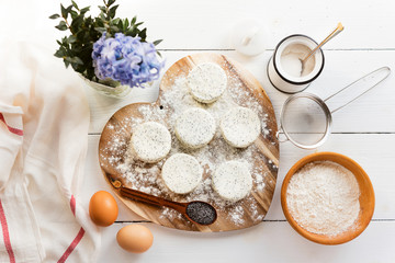raw cheese cakes with poppy seeds on a wooden surface. with ingredients