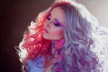 Beautiful woman with bright hair. Bright hair color, hairstyle with curls.