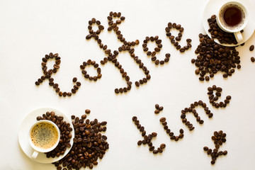 Two cups of espresso and Coffee time text from beans on white table. Top view