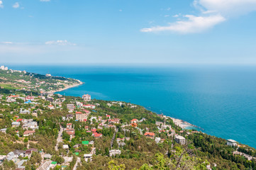 Fototapeta na wymiar Beach at the seaside, blue water, view from above the mountains to the town of Simeiz, Yalta, Crimea