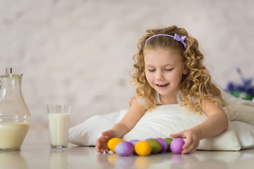 Little pretty girl plays with easter eggs