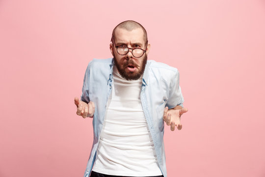 Portrait of an angry man looking at camera isolated on a pink background