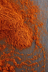 Top view on paprika or red hot chilli pepper powder texture background, shallow depth of field.