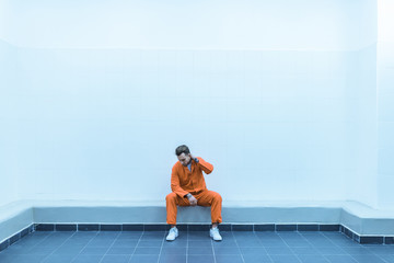 prisoner sitting on bench in prison cell