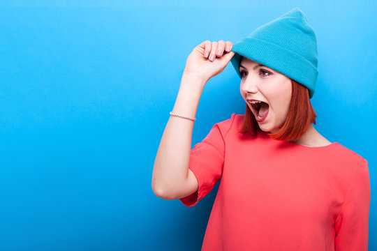 Cool hipster woman wearing a blue hat  on blue background. Copy space available
