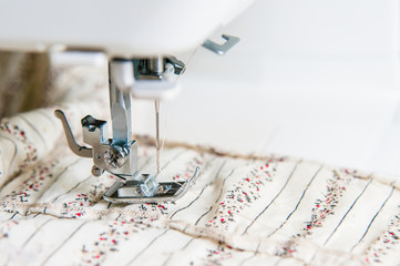 Modern Sewing machine with light flower pattern fabric.