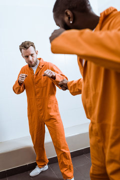 multicultural prisoners fighting in prison room