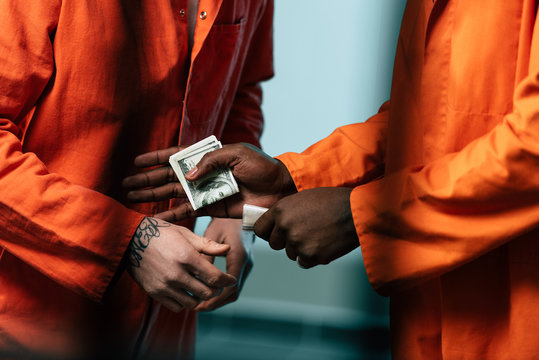 cropped image of prisoner buying drugs at african american inmate