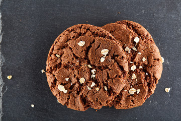 Lowkey picture of two chocolate cookies on dark background, close-up, shallow depth of field