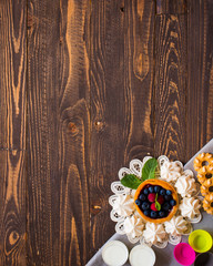 Sweet white meringue and other components on a wooden background, free space for text.