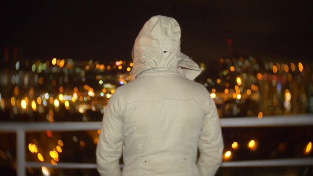 the man is standing with his back. looking forward, cityscape on blurred abstract light night background bokeh. vision of the leader's concept. 4k