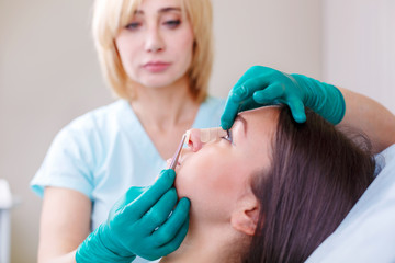 Fototapeta premium Doctor checking woman's face, the eyelid before plastic surgery, blepharoplasty.