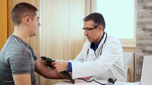 Doctor Measuring The Blood Pressure to Young Athlete