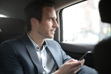 Businessman sitting in the taxi, looking out from the window