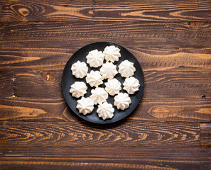 Obraz na płótnie Canvas Sweet white meringue and other components on a wooden background, free space for text.