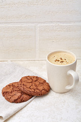 Close-up white cup of coffee with chocolate chip cookies on white background, top view
