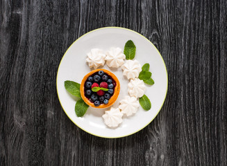 Sweet white meringue and other components on a wooden background, free space for text.