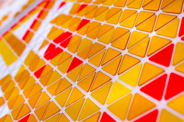tessellation of a plane with yellow, orange and red colored triangles on a white background....