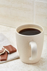 Close-up white cup of coffee with chocolate on white background, top view