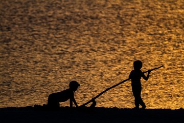 Silhouettes of children on the beach