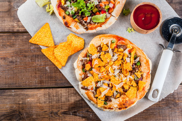 Homemade Mexican Taco PIzza with Nachos  chips, beans, fresh vegetables, beef meat, copy space top view