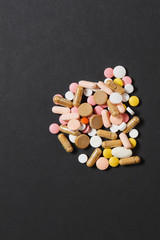 Medication white colorful round tablets arranged abstract on black color background. Aspirin, capsule pills for design. Health, treatment, choice healthy lifestyle concept. Copy space advertisement.