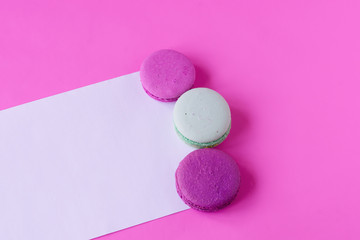 Colorful macaroons on pink background. Space for text