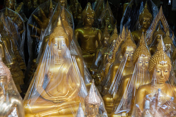 Golden Buddha statue wrapped in plastic, in a shop in Bangkok