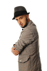 handsome young unshaved man in hat and jacket looking away