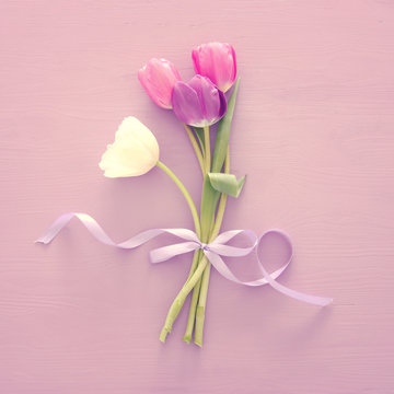 bouquet of pink and white tulips over white wooden background. Top view.