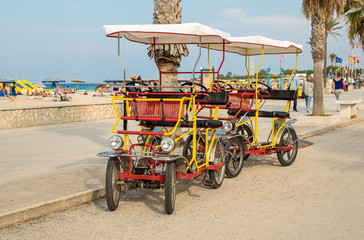 Rickshaw bicycle for rental for tourists parked near beach in San Vito Lo Capo, Sicily
