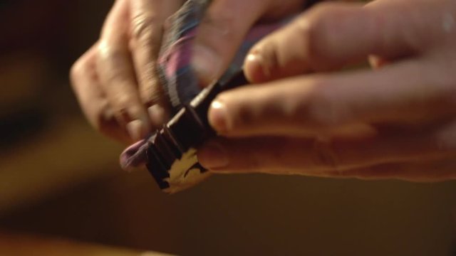 Extreme closeup view of male master doing carpentry on furniture manufacture, and polishing wooden detail after varnish covering slow motion