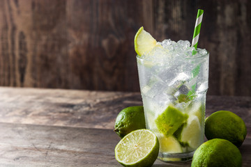 Caipirinha cocktail in glass on wooden table background. Copyspace