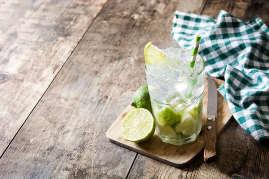 Caipirinha cocktail in glass on wooden table background. Copyspace