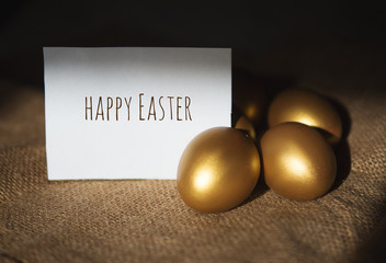 Golden eggs on a dark background and the words happy Easter