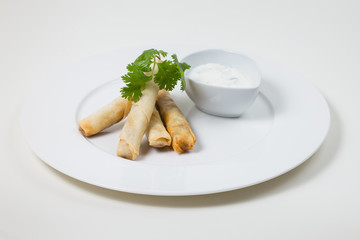 Spring Rolls and dip on a white plate on a white background isolated