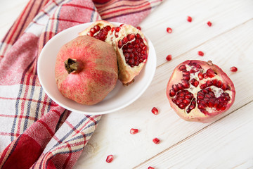 pomegranate with seeds.red tablecloth.white wooden table.