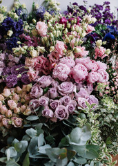 A lot of fresh blossoming flowers (roses, peonies, ranunculus, tulips, eucalyptus) at the florist shop