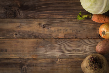 Borsch and its ingredients on a wooden background