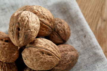 A stack of walnuts piled together and on rustic wooden background, shallow depth of field, selective focus