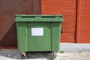 green garbage bin on the street